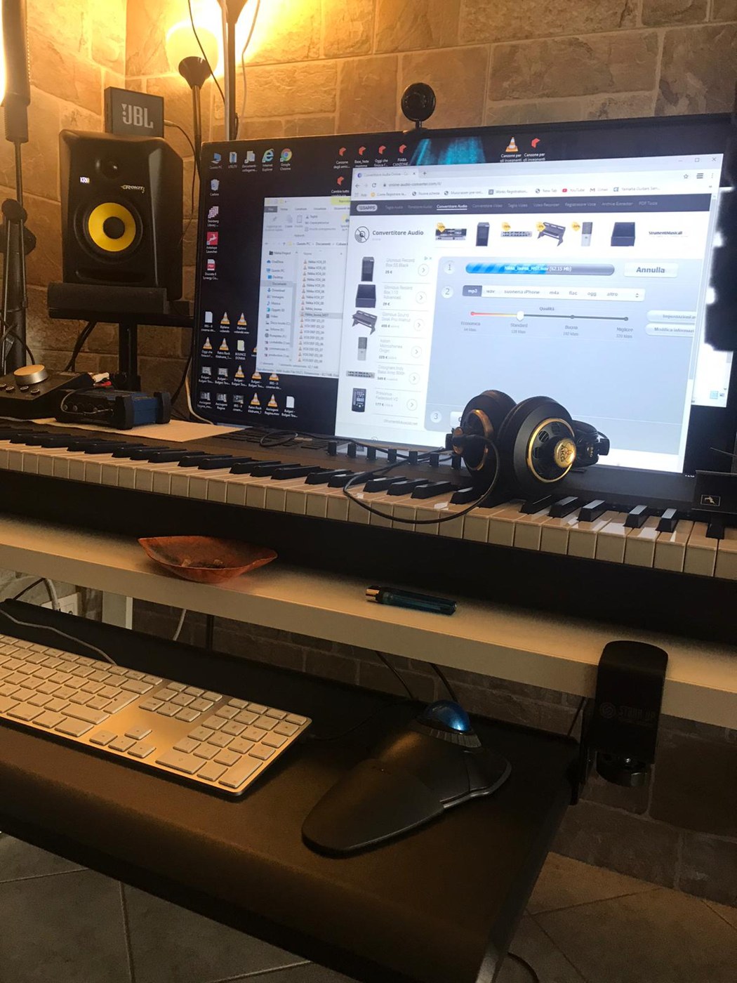 Postazione di produzione musicale con computer, tastiera e monitor audio